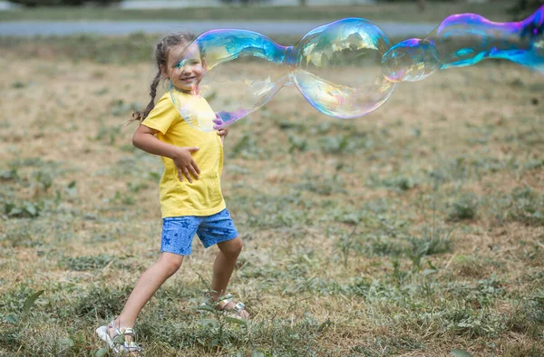 Ένα Χαρούμενο Κορίτσι Πιάνει Μεγάλες Σαπουνόφουσκες Ένα Παιδί Παίζει Στο — Φωτογραφία Αρχείου