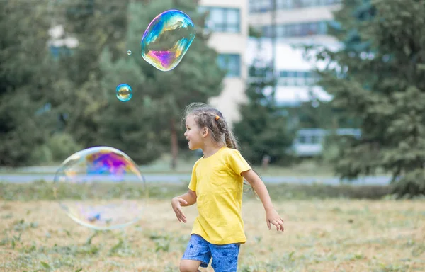 Happy Girl Catches Big Soap Bubbles Child Plays Street Light — 图库照片