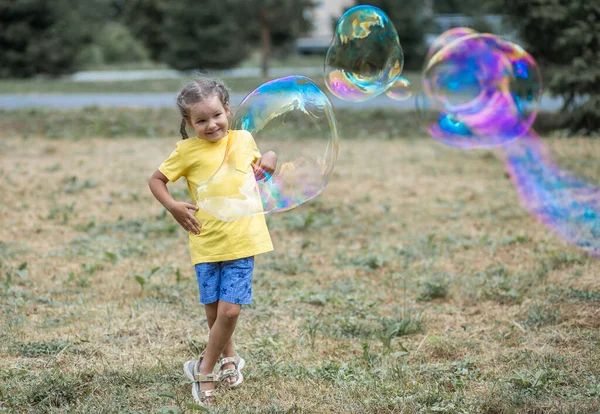 Happy Girl Catches Big Soap Bubbles Child Plays Street Light — 스톡 사진