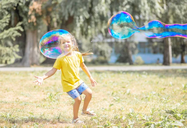 Happy Girl Catches Big Soap Bubbles Child Plays Street Light — 图库照片