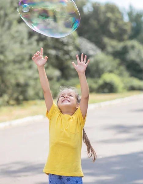 Happy Girl Catches Big Soap Bubbles Child Plays Street Light — 图库照片