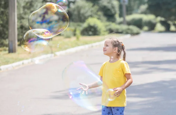 Happy Girl Catches Big Soap Bubbles Child Plays Street Light — 图库照片