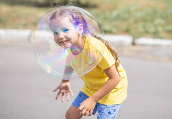 Happy Girl Catches Big Soap Bubbles Child Plays Street Light — 图库照片