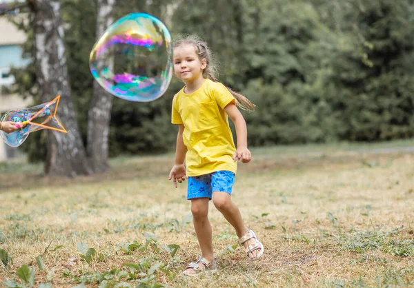 Happy Girl Catches Big Soap Bubbles Child Plays Street Light — 图库照片
