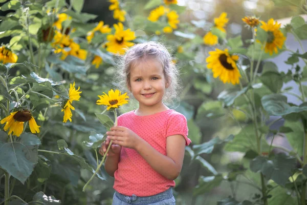 Klein Gelukkig Meisje Een Roze Shirt Tussen Zonnebloemen Felgele Bloemen — Stockfoto