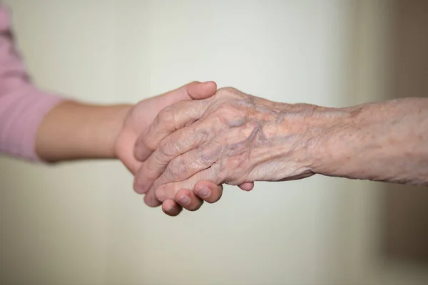 孩子的手在奶奶的手里 老女人的皮肤是棕色的 母亲的爱和呵护 — 图库照片