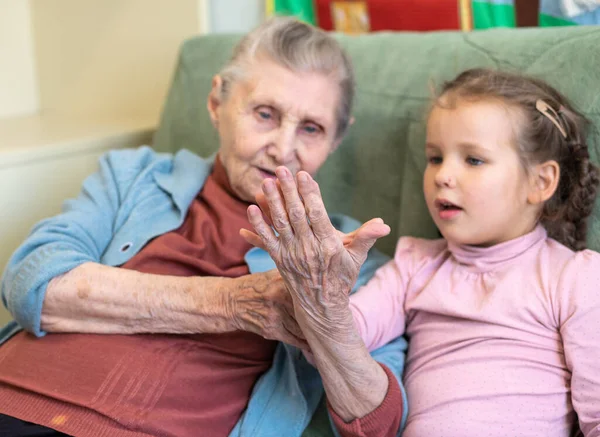 Portrait of an old woman and a little girl, grandmother hugs her granddaughter, family ties, old age and youth, 90 years, wrinkles on an old face, beautiful old age, a woman and a child.