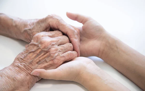 The hands of the child in the hands of the grandmother, the old brownish skin in the elderly woman, motherly love and care.