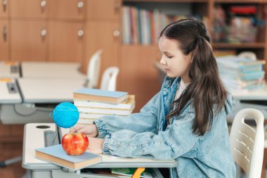 Parlak renkler ve neşeli ruhlar, bir kız öğrencinin eğitici materyalleriyle meşgul olduğu gibi sınıfı dolduruyor..