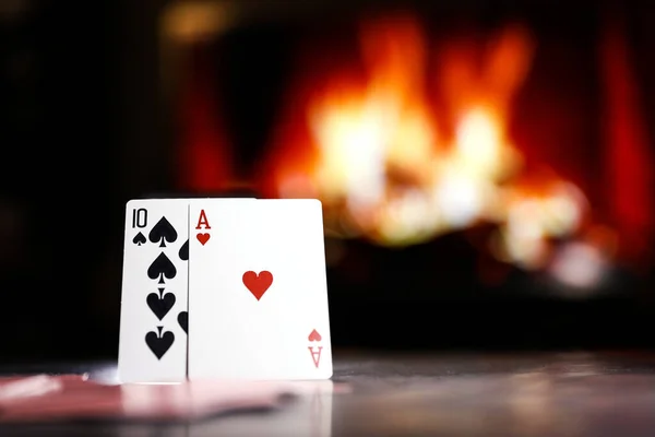 A pair of aces on a deck of playing cards against the background of a burning fireplace. Online gambling. Gambling addiction