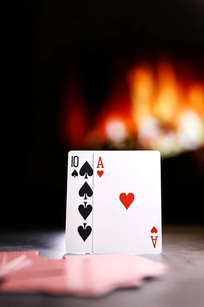 A pair of aces on a deck of playing cards against the background of a burning fireplace. Online gambling. Gambling addiction