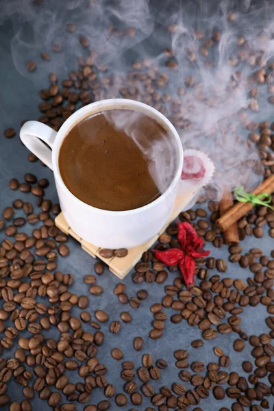  Kahve çekirdekleri ile dolu beyaz bardak koyu gri arka plana yakın duruyor. Kahve kupası. Sabah espresso.