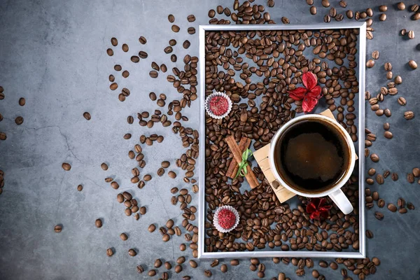 Kırmızı çikolata ve kırmızı çiçekli fotoğraf çerçevesi şeklinde kahve çekirdekleri ile dolu beyaz bir fincanın düz manzarası vardı. Sabah espresso. Kahve kupası..