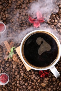 Kahve çekirdekleri ile dolu beyaz bardak koyu gri arka plana yakın duruyor. Kahve kupası. Sabah espresso.