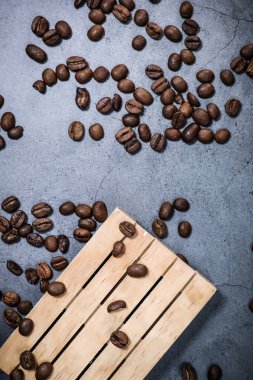 Ahşap palette kahve çekirdekleri ve koyu gri arka plan. Kahve molası. Sabah espresso.