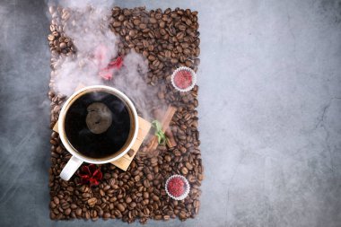 Kırmızı çikolata ve kırmızı çiçekli fotoğraf çerçevesi şeklinde kahve çekirdekleri ile dolu beyaz bir fincanın düz manzarası vardı. Sabah espresso. Kahve kupası..