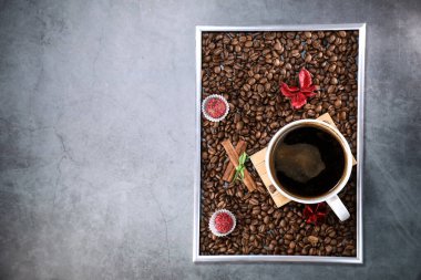 Kırmızı çikolata ve kırmızı çiçekli fotoğraf çerçevesi şeklinde kahve çekirdekleri ile dolu beyaz bir fincanın düz manzarası vardı. Sabah espresso. Kahve kupası..