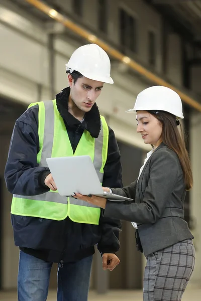 Beyaz bir şapka ve iş elbisesi içinde kadın bir fabrika müdürünün portresi ve iş elbiseli bir fabrika mühendisi. Helikopter imalatçısının çalışma sürecini kontrol etmek.