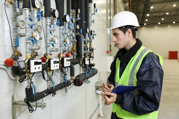Kafkasyalı bir adamın portresi, fabrika mühendisi iş kıyafetleri içinde helikopter imalatında çalışma sürecini kontrol ediyor..