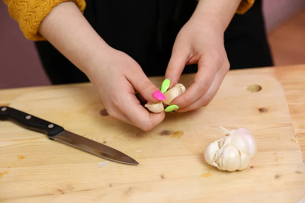 Young woman cooking in a kitchen. Housewife preparing vegetables for cooking. Peel onion. Cooking baked zucchini