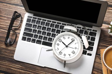 Bilgisayarlı, malzemeli, kahveli ve alarmlı ofis çalışma masasının en üst görüntüsü. Sabah ya da teslim tarihi konsepti.