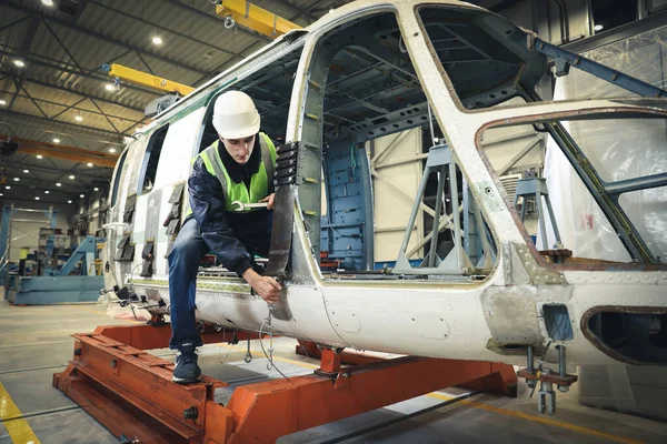Kafkasyalı bir adamın portresi, fabrika mühendisi iş kıyafetleri içinde helikopter üreticisinin çalışma sürecini kontrol ediyor..