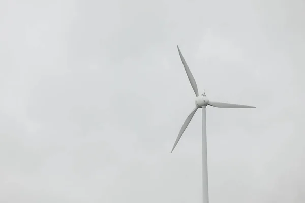 Wind turbines field in a stormy day with strong wind and rain. Wind farm eco field. Green ecological power energy generation.