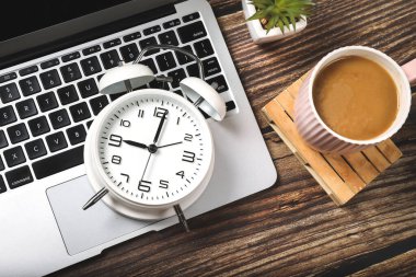 Bilgisayarlı, malzemeli, kahveli ve alarmlı ofis çalışma masasının en üst görüntüsü. Sabah ya da teslim tarihi konsepti.