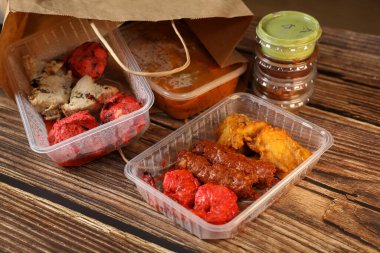 Geleneksel Hint yemeklerini tahta bir masada plastik bir kutuda görmek. Hindistan fast food teslimatı. Evde ye..