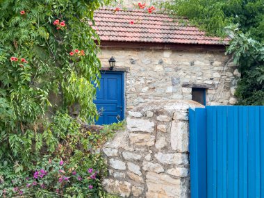 Türkiye 'nin eski Datca kentindeki tarihi taş evler, mavi kapılı ve pencereli sokak manzarası. Yüksek kalite fotoğraf