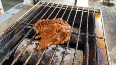 Sulu salamura edilmiş tavuk dumanlı ızgarada cızırdıyor.