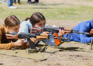 POLTAVA, UKRAINE - 13 Mayıs 2021: Yerel askeri alanda geniş çaplı bir askeri eğitim (makineli tüfek ateşi) sırasında okul öğrencileri