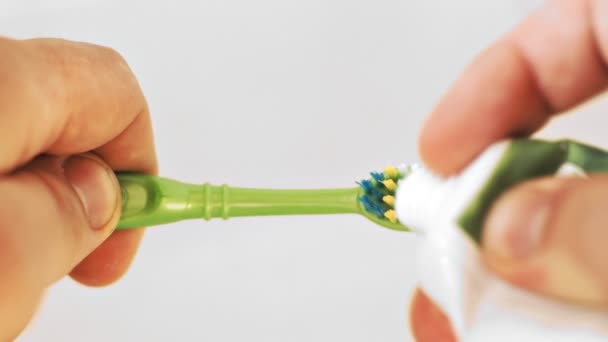 Toothbrush, toothpaste, squeezing toothpaste on the brush. Toothbrush on a light background Royalty Free Stock Footage