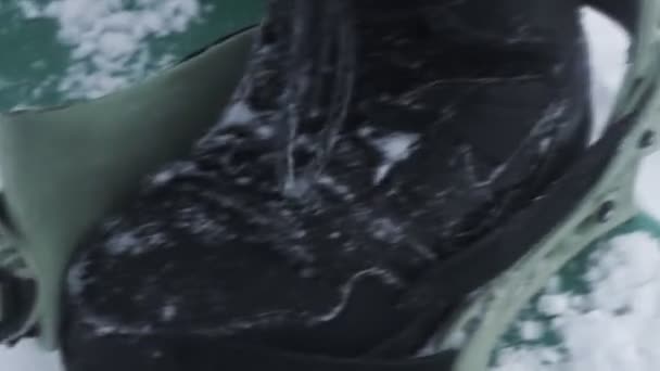 Το snowboarder εξασφαλίζει τις μπότες στο το snowboard — Αρχείο Βίντεο