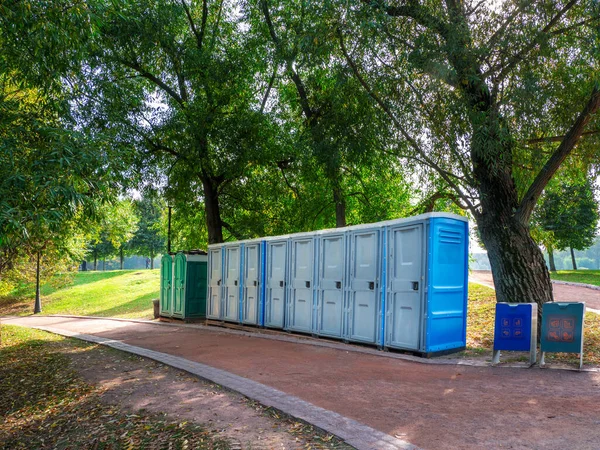 Bagno portatile in natura. Lunga fila di cabine biologiche portatili nel parco di Mosca. Linea di servizi igienici chimici per la vacanza, festival. — Foto Stock