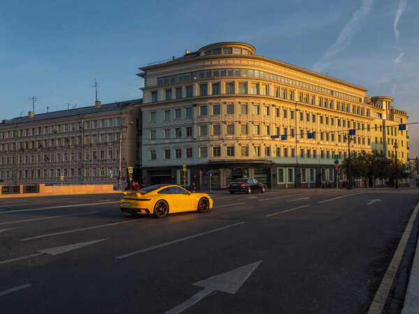 Russia, Moscow, September,30 2020. Yellow Porsche 911 in traffic on the street in Moscow in the evening.