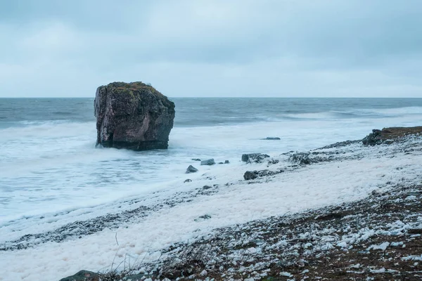 波涛汹涌 软弱无力 一块大石头从海里突出来 白沙滩上的风暴浪花白沫滚在岩石海岸上 极地野生景观 — 图库照片