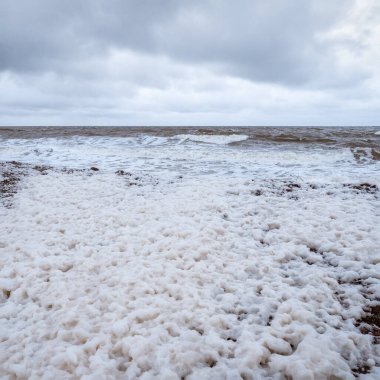 Dalgalar ve beyaz köpüklü dramatik minimalist deniz manzarası.