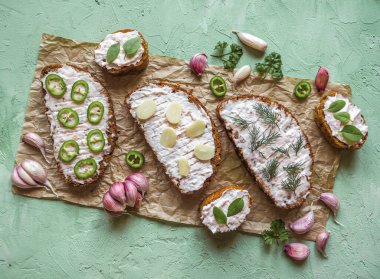 Sarımsaklı ekmek, baget dilimleri, sarımsaklı tereyağı, bitkiler. Üst görünüm. 