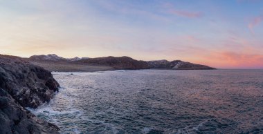 Teriberka yakınlarındaki Barents Denizi kıyısındaki inanılmaz kara çakıl taşı plajı. Panoramik manzara. Kola Yarımadası 'nda kış, Murmansk Oblastı, Rusya.