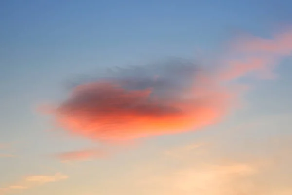 Sky at sunset. A bright red cloud in the evening sky.