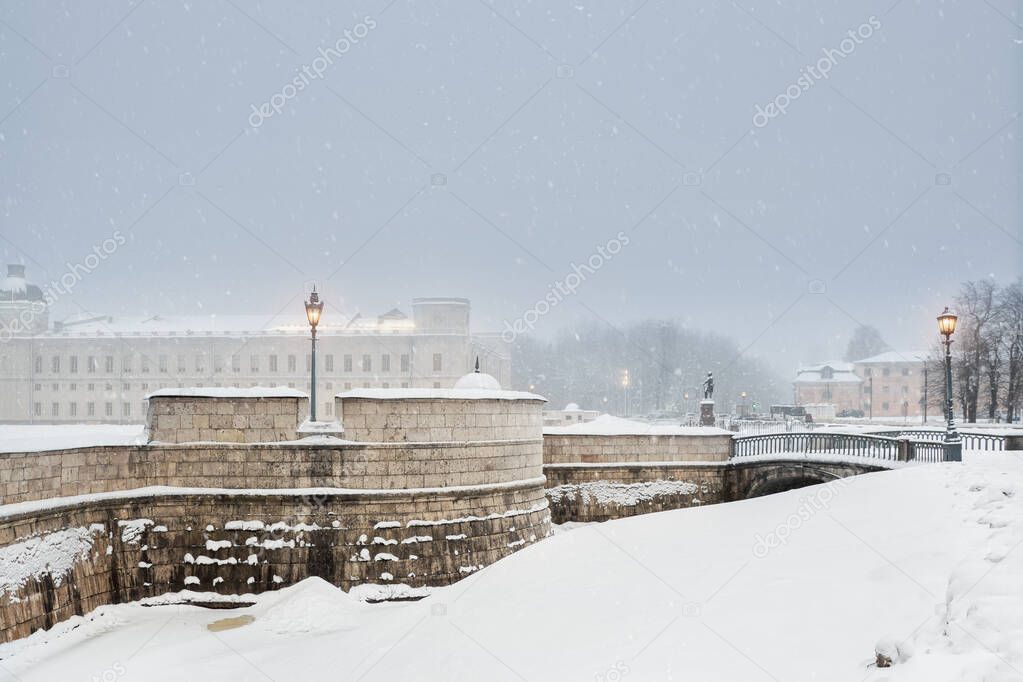 Urban winter view of the ancient Russian city of Gatchina. The old palace in winter is illuminated in the evening. 