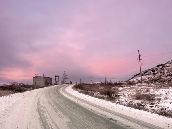 雪の道を離れて丘の間の距離に広がってオンにします コラ半島 夜明けの魔法の紫色 — ストック写真