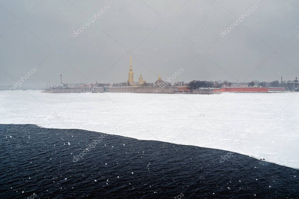Beautiful spring cityscape with snowfall. Contrasting view of the Peter and Paul Fortress in winter. Saint-Petersburg. Russia.