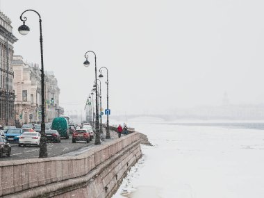Yumuşak odaklı kar yağışı. St. Petersburg 'da ilkbahar karı. Neva Nehri seddindeki trafik sıkışıklığı. Rusya.