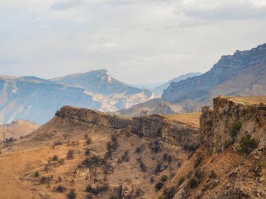 Kayalık çıkıntı, uzak mesafeye doğru uzanan uçurum kırmızı desenli dağların arka planına karşı. Dağıstan. 