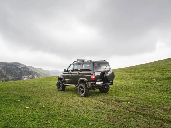 stock image Russia. Dagestan. Hunzah. May 2021. Off-road Uaz patriot vehicle on the edge of a steep cliff. Extreme mountain safari.