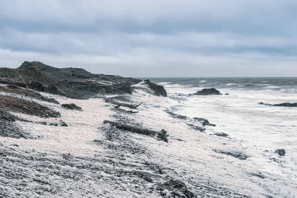 暴风雨般的大海浪花白沫滚在岩石海岸上 — 图库照片