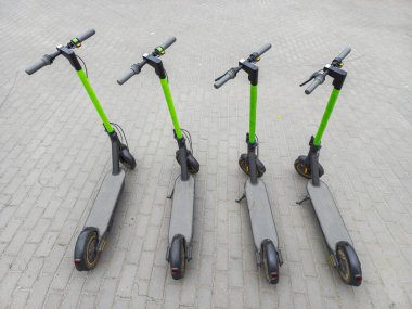 Asfaltta iki mobilet var. Yaz şehrinde dört tane park etmiş scooter. Modern gençlik ulaşım yöntemi. Üst görünüm.