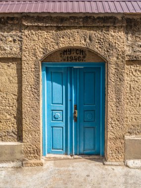Russia. Dagestan. Choh village. May 2021. Vintage blue wooden door with the inscription of the family name Musu-1946 (in translation Musi) in a mountain authentic village. Dagestan.